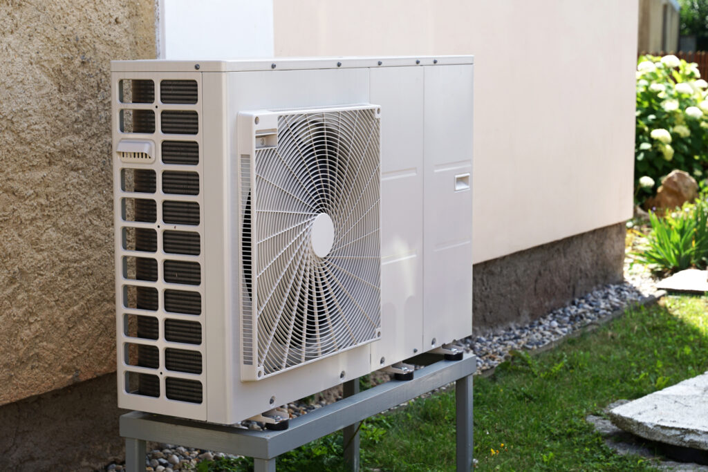 Angled view of an air-source heat pump outside of a residential building in Florida