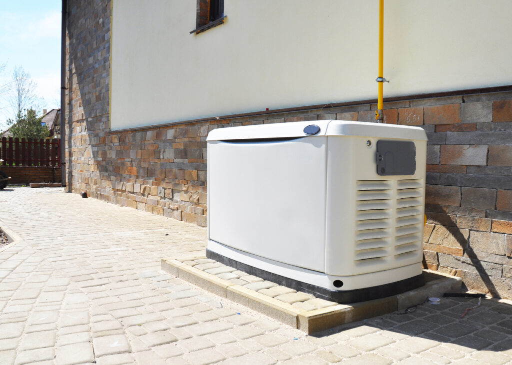 a generator in the backyard of a home on a stone patio